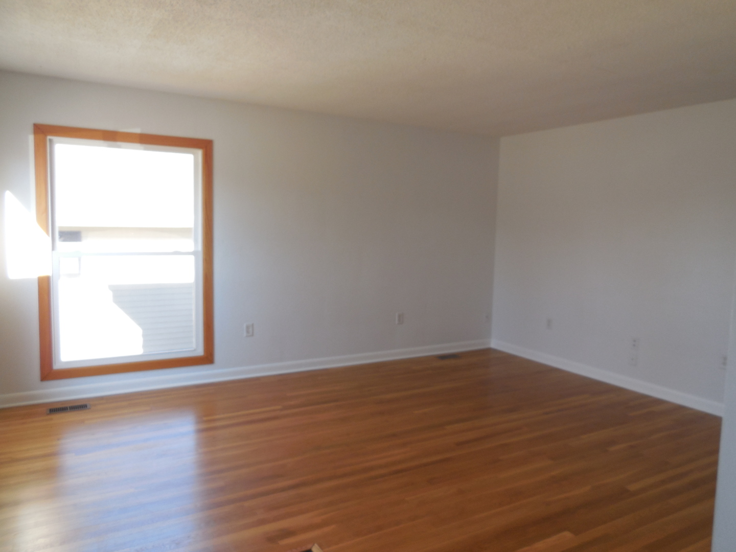 1220 Robin Road Dixon, IL 61021 - Photo 3 of 18 a view of an empty room with wooden floor and a window