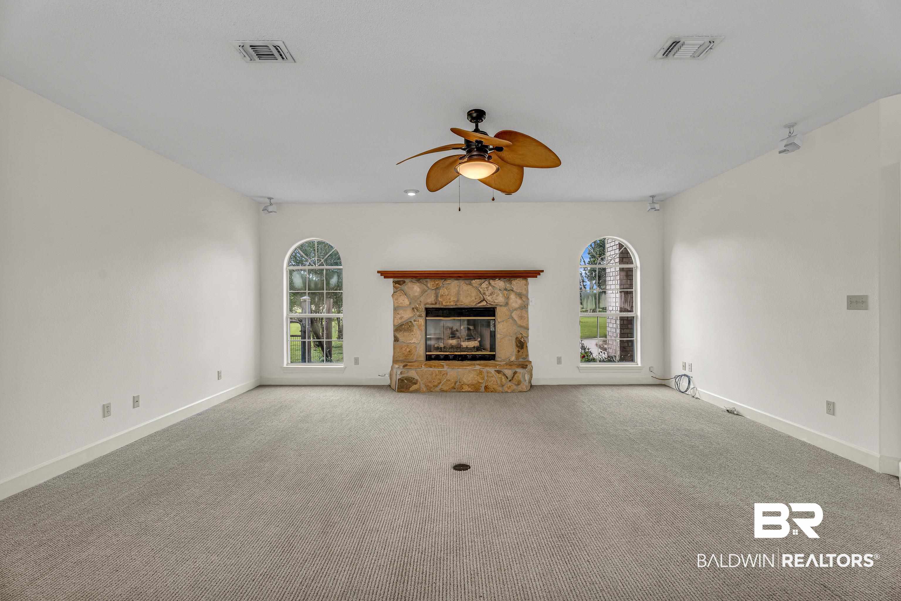 9530 Pilgrim Drive Elberta, AL 36530 - Photo 5 of 61 Unfurnished living room featuring a ceiling fan, baseboards, visible vents, and a healthy amount of sunlight