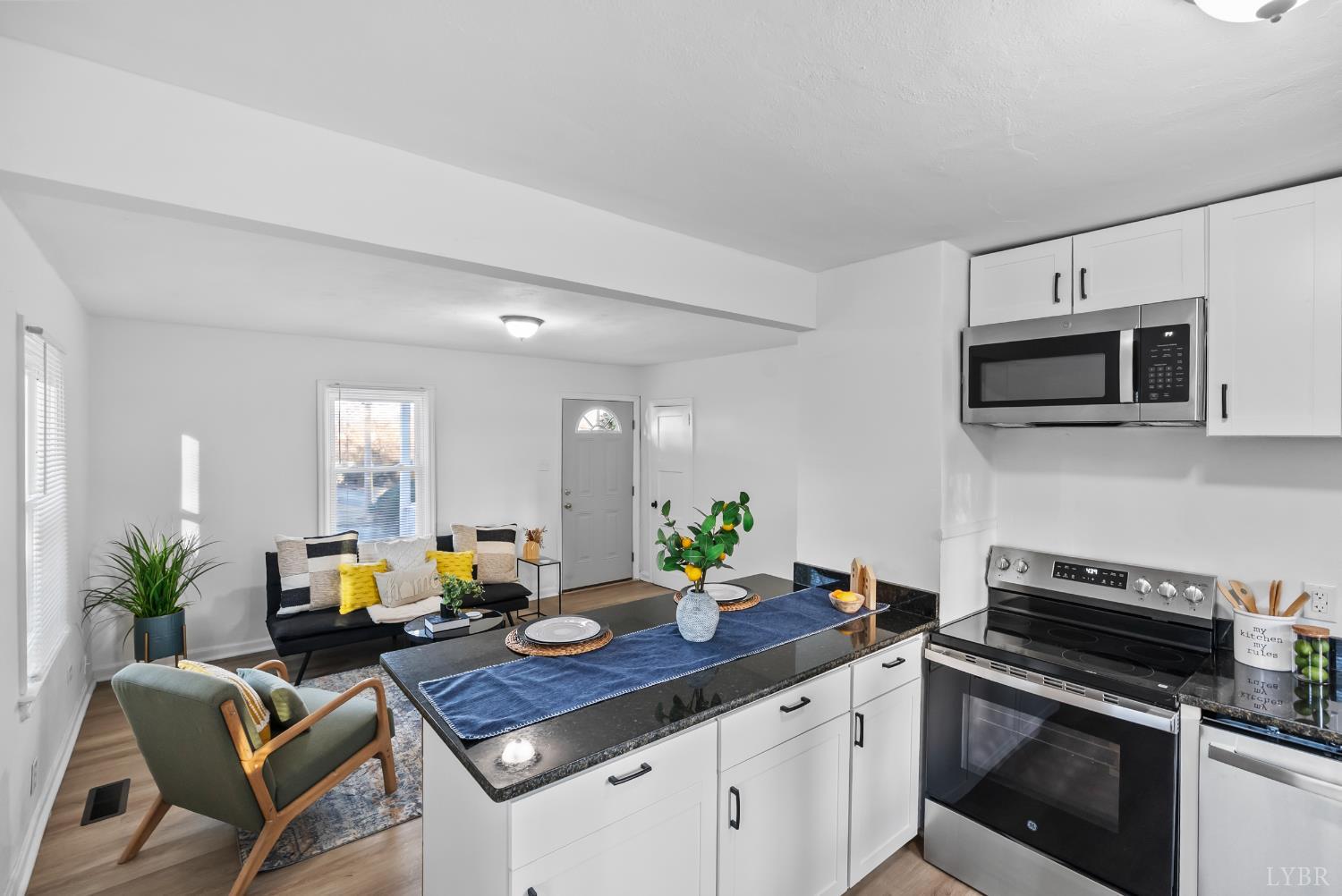 1201 Brandon Road Lynchburg, VA 24502 - Photo 14 of 25 a kitchen with stainless steel appliances a kitchen island hardwood floor sink stove dining table and chairs