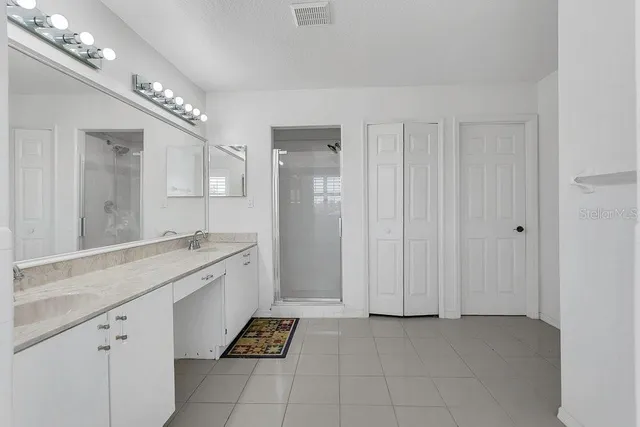 a spacious bathroom with a granite countertop sink a mirror and a