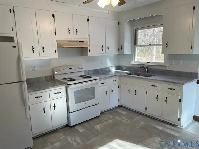 a kitchen with white cabinets white stainless steel appliances and sink