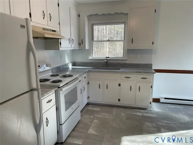 a kitchen with granite countertop white cabinets and white appliances