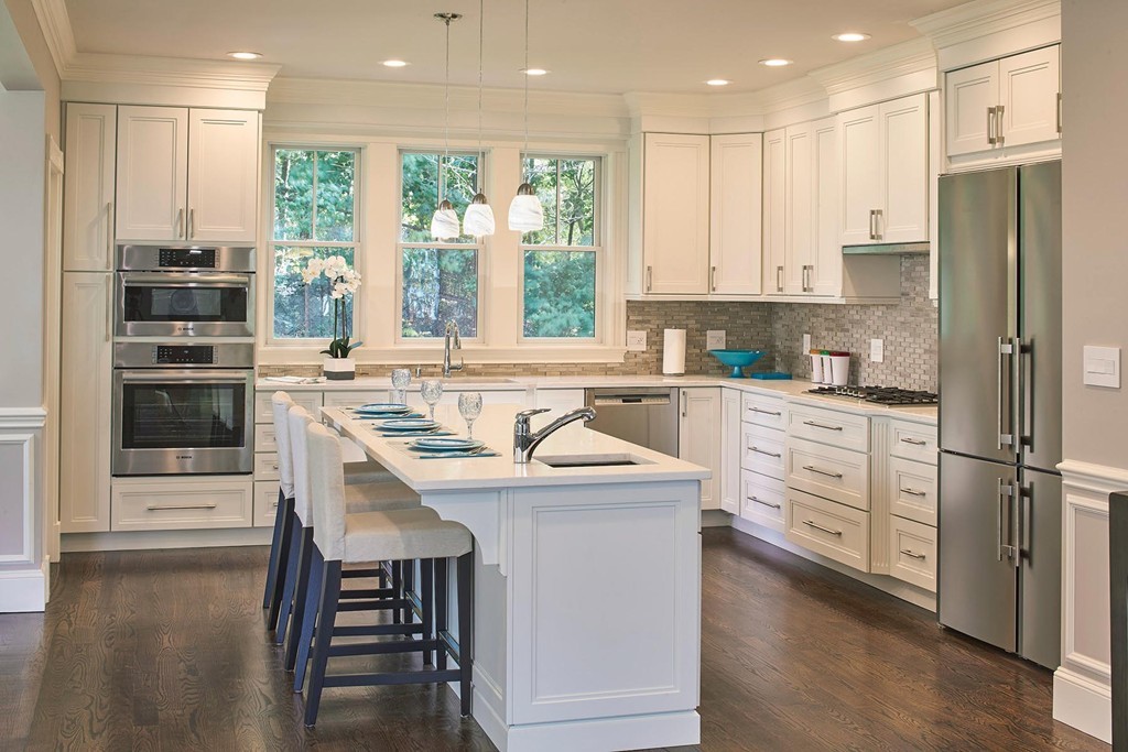 160 Bellingham Road Brookline, MA 02467 - Photo 4 of 7 a kitchen with stainless steel appliances granite countertop a stove a sink a refrigerator and white cabinets with wooden floor