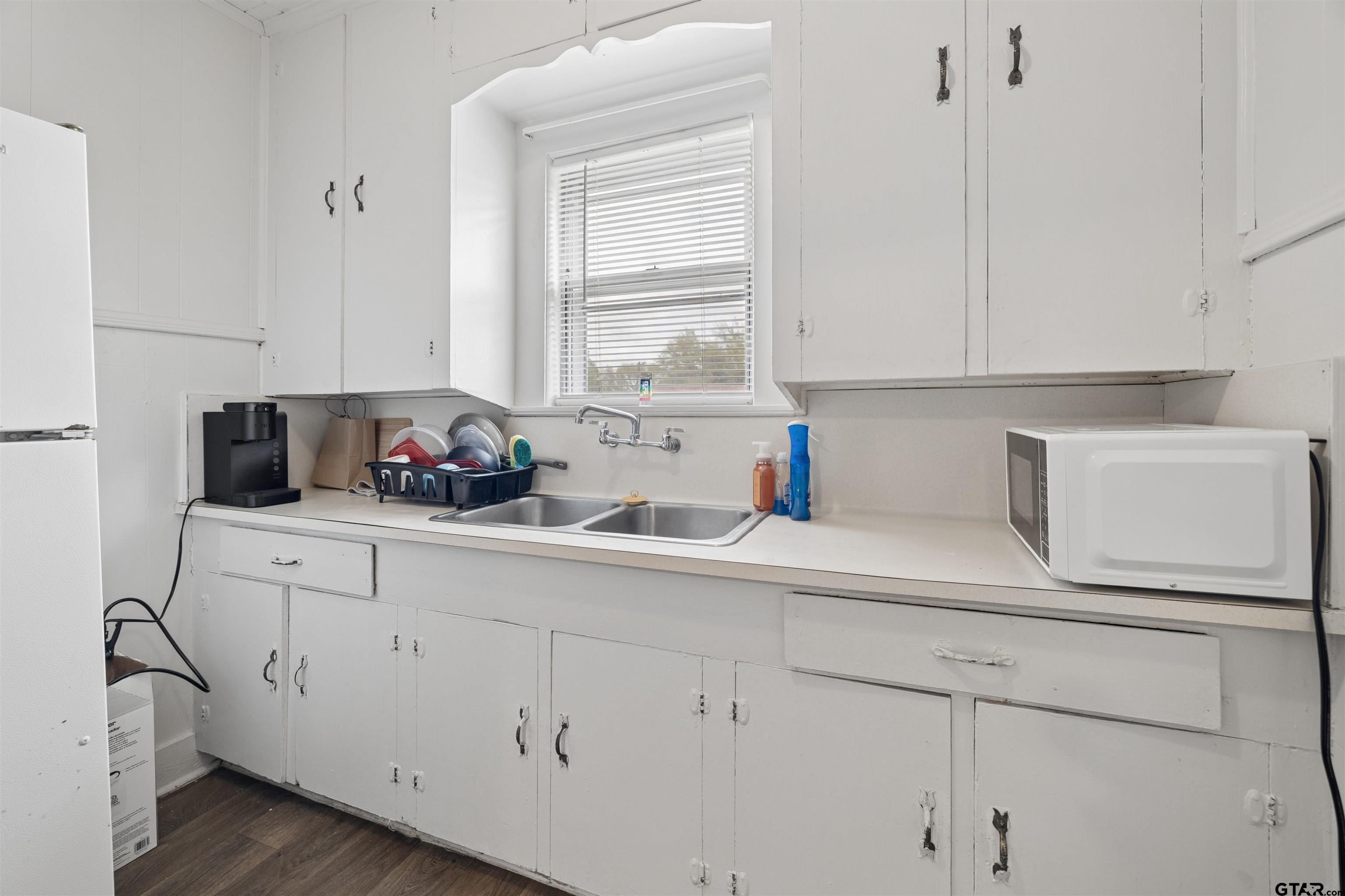 1010 Maple Street Kilgore, TX 75662 - Photo 15 of 20 a kitchen with white cabinets and white appliances