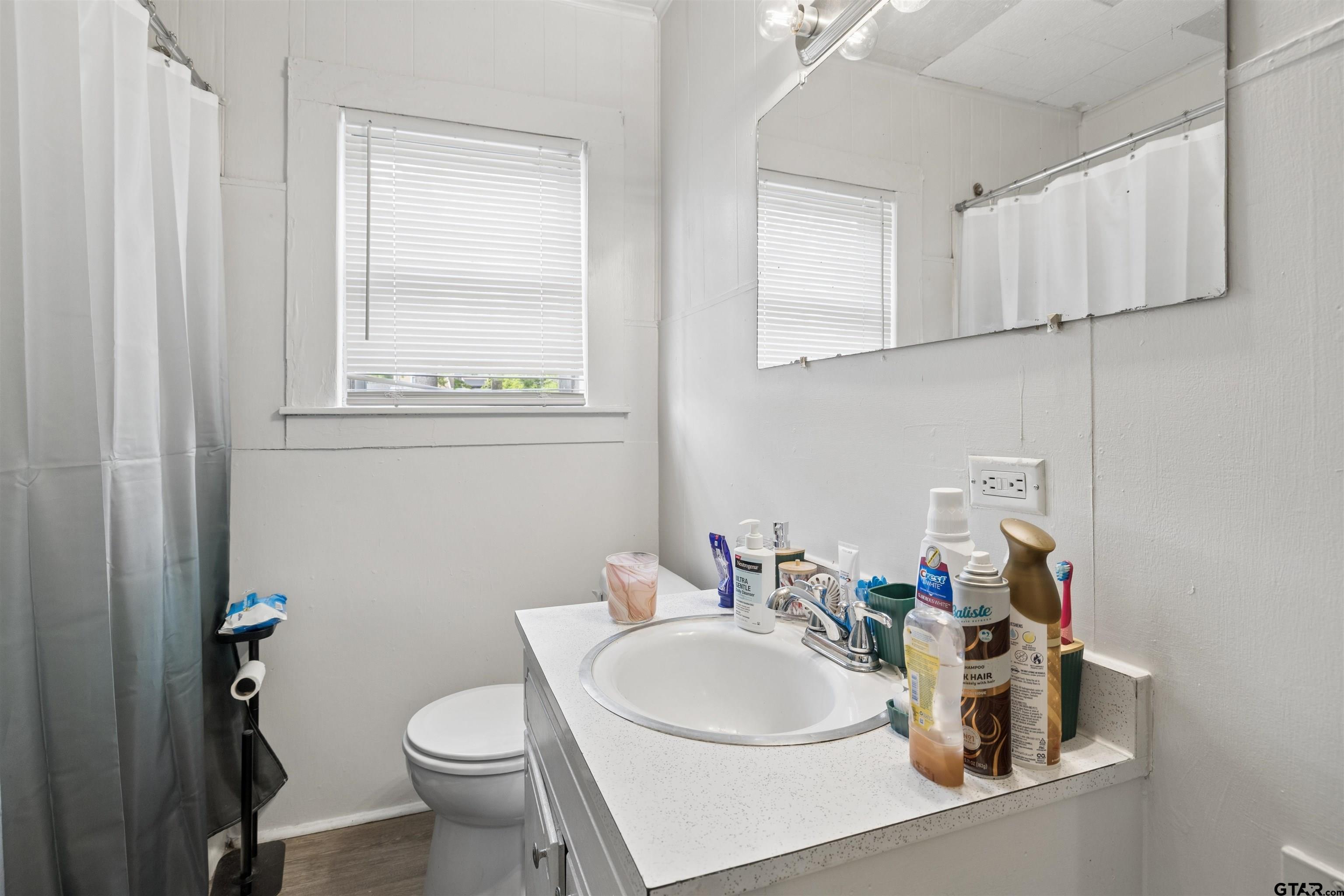 1010 Maple Street Kilgore, TX 75662 - Photo 10 of 20 a bathroom with a sink toilet and mirror