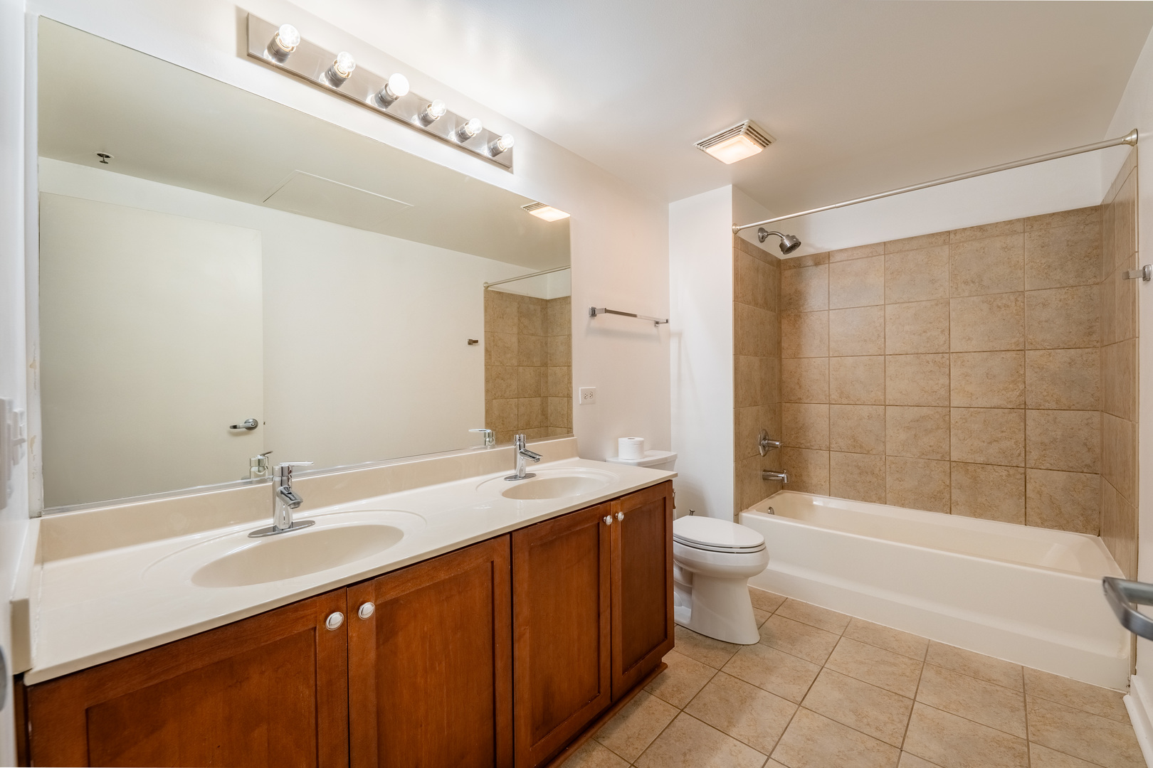 50 East 16th Street, Unit 411 Chicago, IL 60616 - Photo 16 of 22 a bathroom with a double vanity sink toilet mirror and bathtub