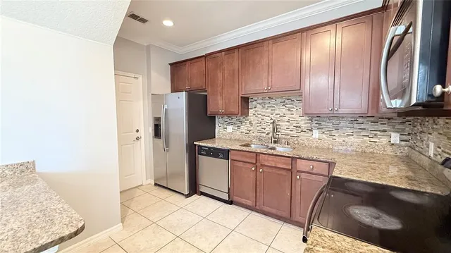 a kitchen with stainless steel appliances granite countertop a sink stove and refrigerator