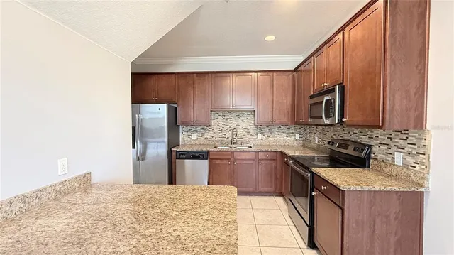a kitchen with stainless steel appliances granite countertop a stove microwave and sink