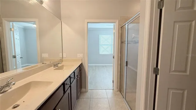 a bathroom with a double vanity sink a mirror and a shower