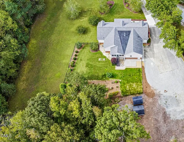 an aerial view of a house with a garden and lake view