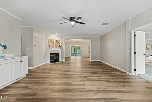 a view of an empty room with a fireplace and window