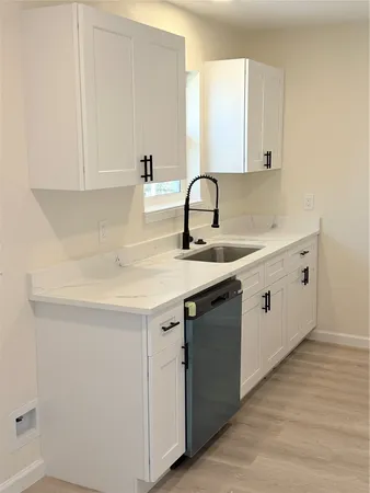a kitchen with a sink cabinets and wooden floor