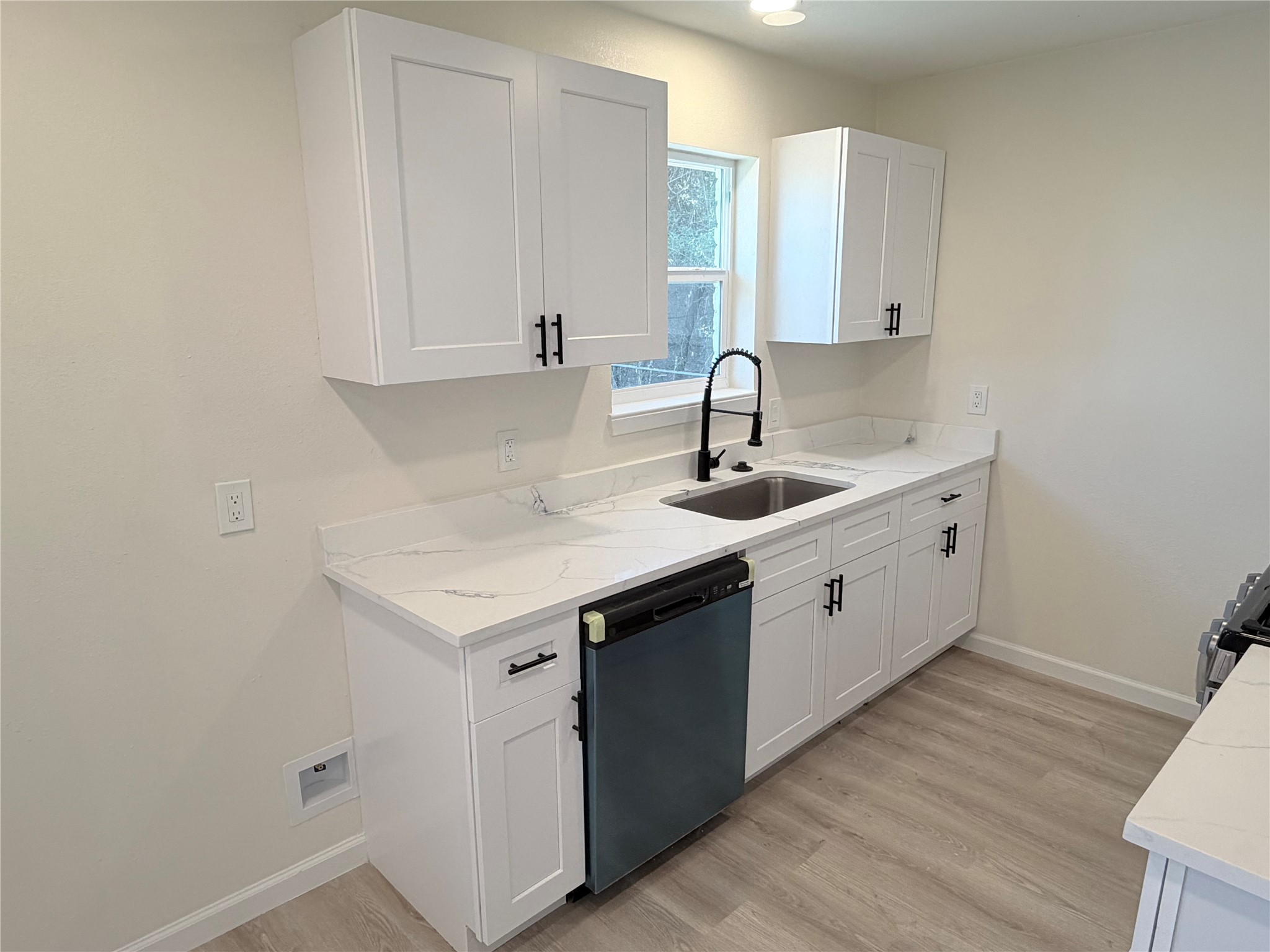 15302 Corsair Road Houston, TX 77053 - Photo 20 of 24 a kitchen with a sink dishwasher and white cabinets with wooden floor