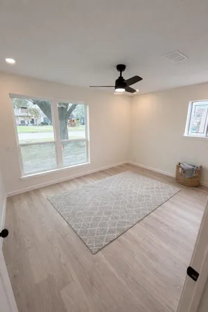 an empty room with windows and ceiling fan view