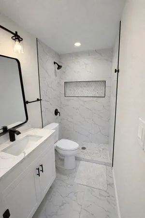 a bathroom with a sink a toilet and shower