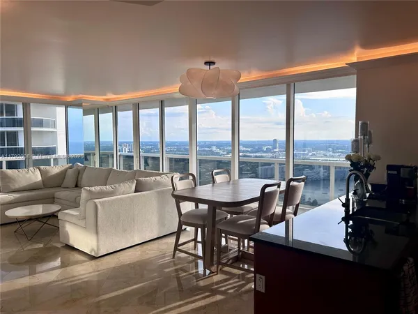 a living room with furniture and floor to ceiling windows