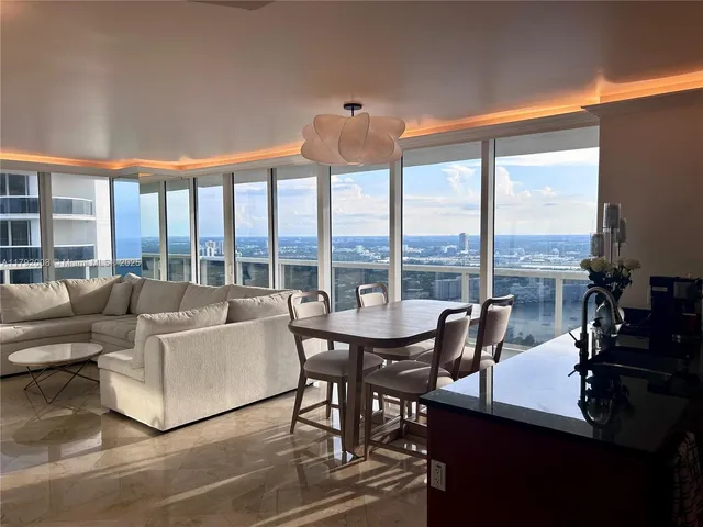 a living room with furniture and floor to ceiling windows