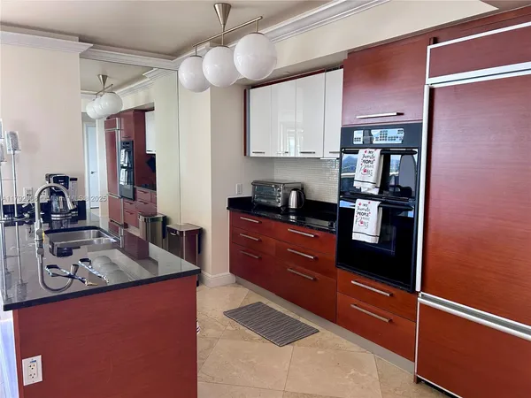 a kitchen with stainless steel appliances granite countertop a refrigerator and a stove top oven