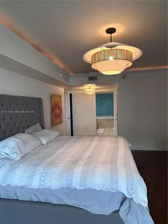 a bedroom with a bed and a chandelier