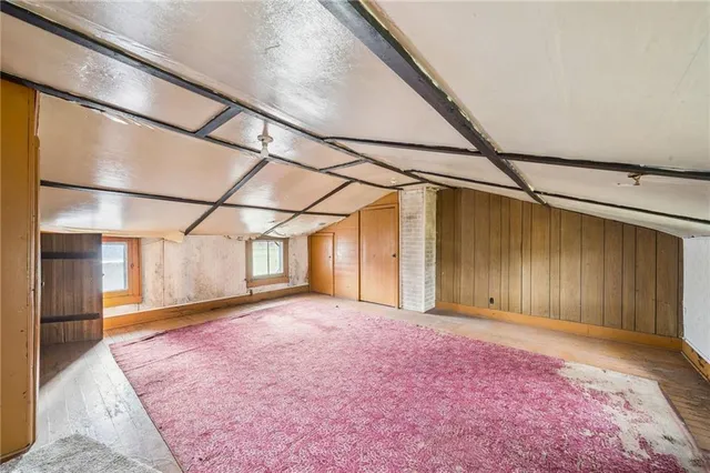 a view of a big room with wooden floor and brick walls