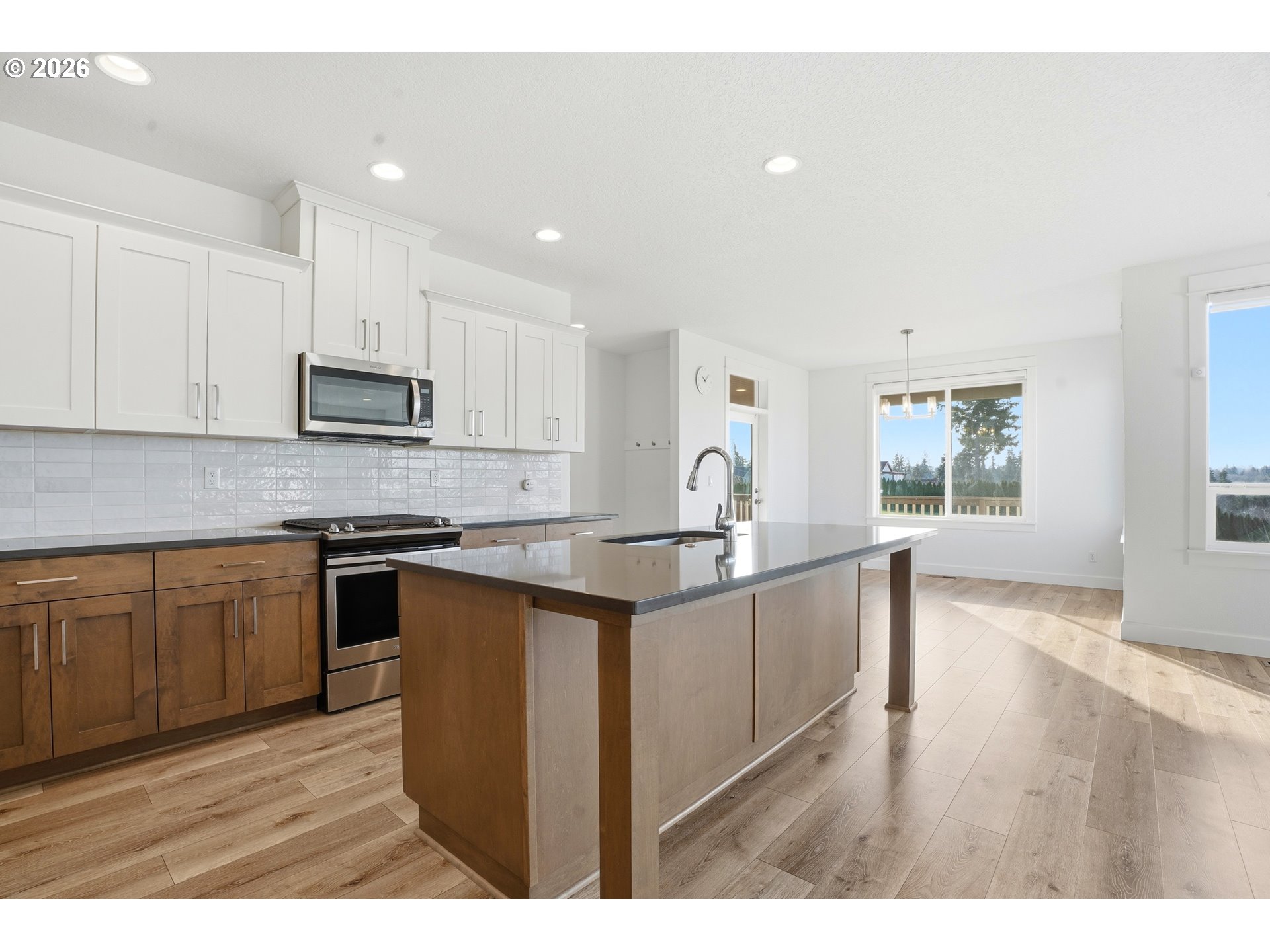 14146 South Cleveland Street Oregon City, OR 97045 - Photo 11 of 46 a kitchen with stainless steel appliances granite countertop a sink a stove a microwave a center island and windows