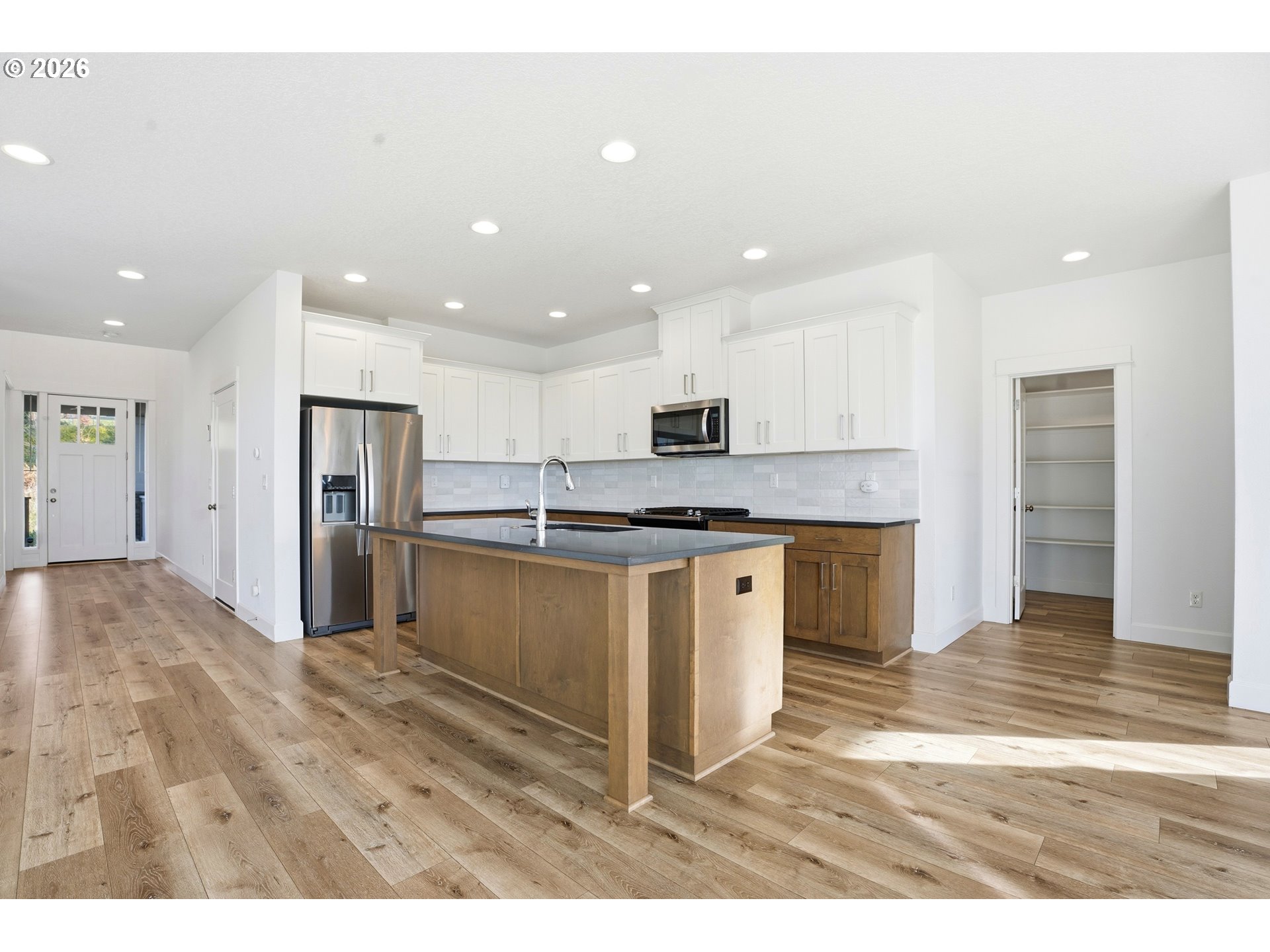 14146 South Cleveland Street Oregon City, OR 97045 - Photo 13 of 46 a kitchen with stainless steel appliances kitchen island granite countertop a stove top oven a refrigerator and a sink