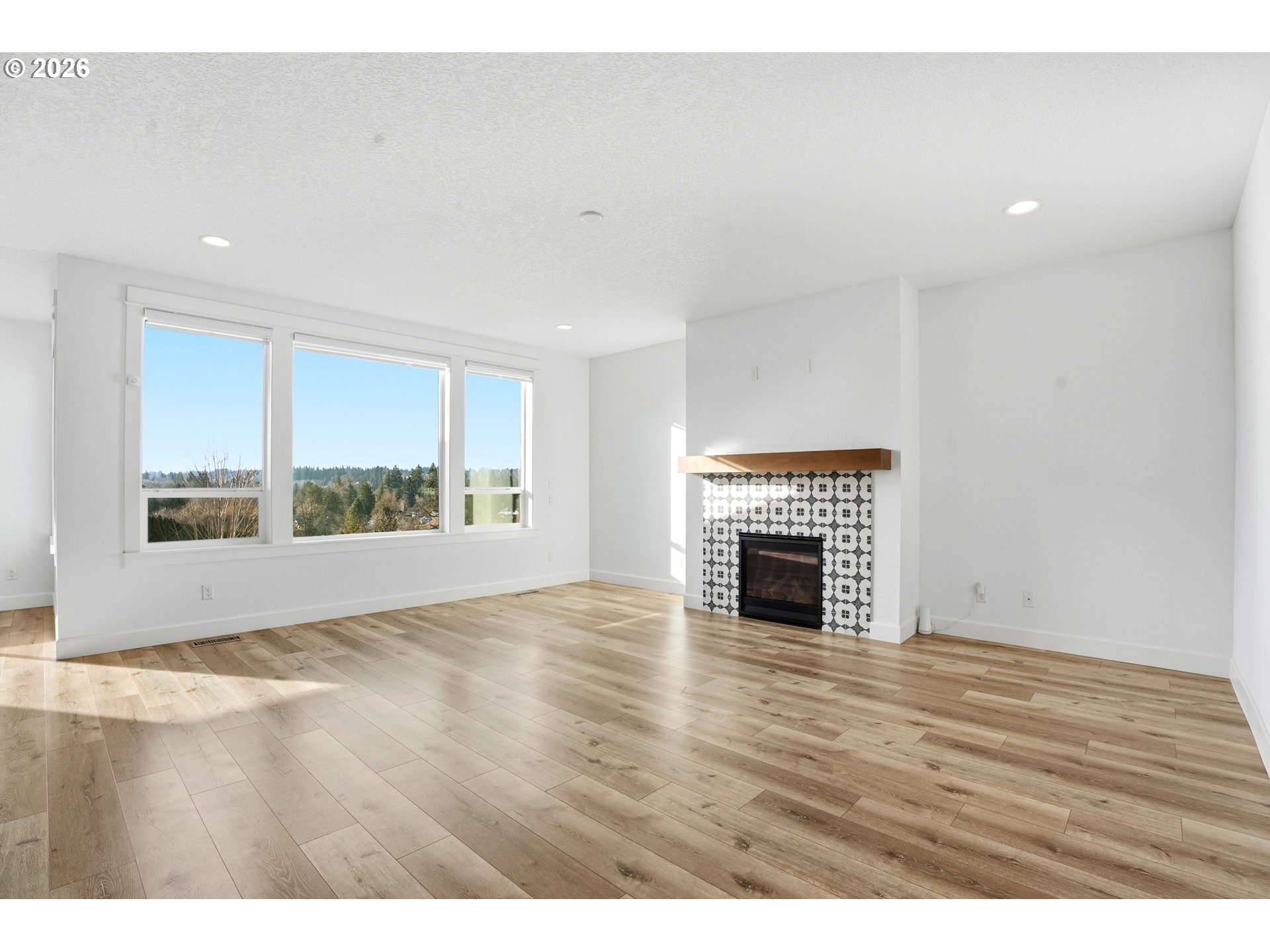 14146 South Cleveland Street Oregon City, OR 97045 - Photo 18 of 46 a view of an empty room with a fireplace and wooden floor