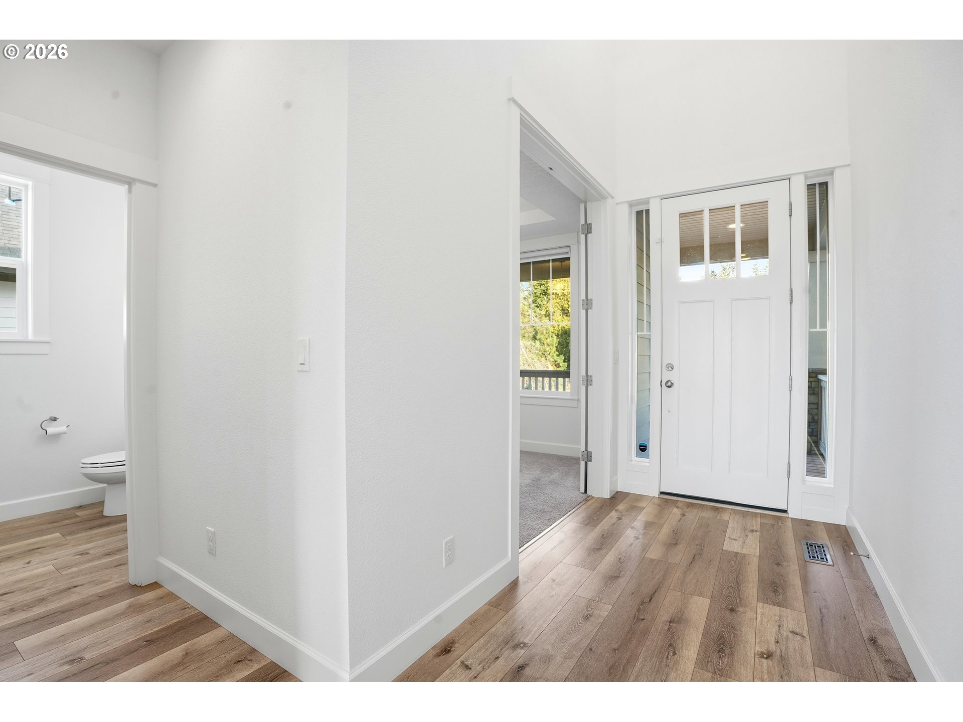 14146 South Cleveland Street Oregon City, OR 97045 - Photo 6 of 46 a view of an empty room with wooden floor and a bathroom