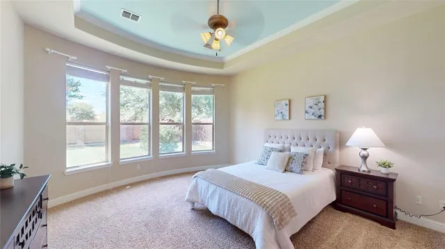 a spacious bedroom with a large bed and a chandelier