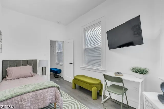 a bedroom with a bed a couch and a flat screen tv