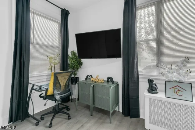 a view of a workspace with furniture and a flat screen tv