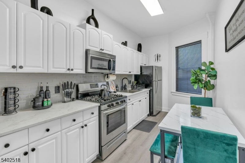 68 Pine Street Montclair, NJ 07042 - Photo 8 of 23 a kitchen with stainless steel appliances granite countertop a refrigerator sink and white cabinets