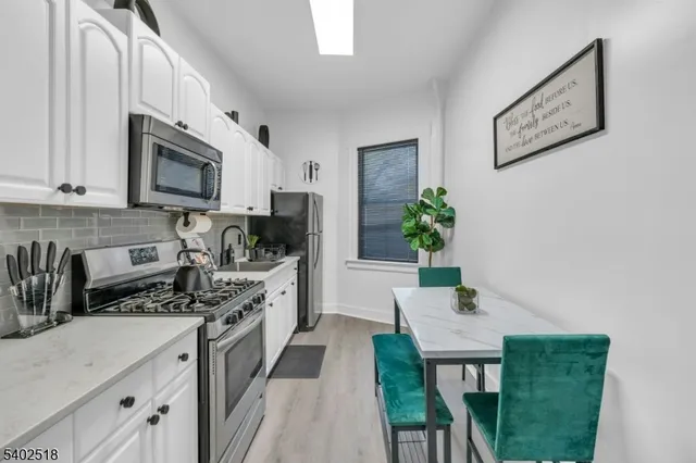 a kitchen with stainless steel appliances microwave stove refrigerator sink and cabinets