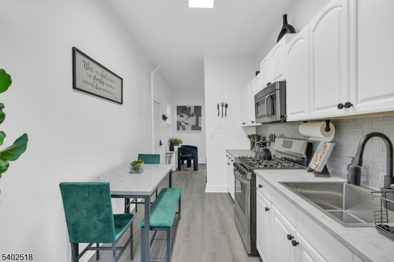 68 Pine Street Montclair, NJ 07042 - Photo 10 of 23 a kitchen with stainless steel appliances a white table and chairs in it
