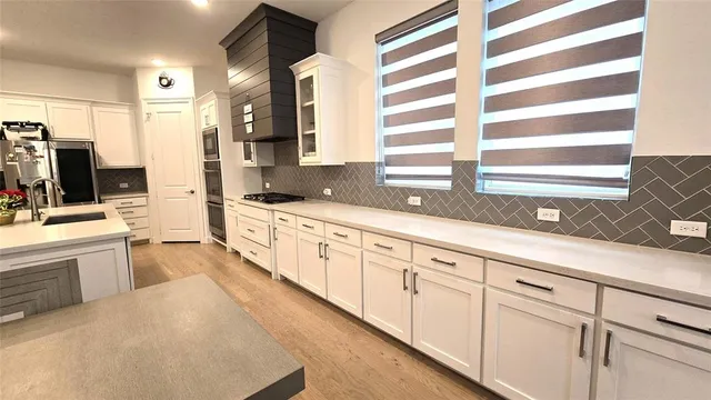 a kitchen with a table chairs refrigerator and cabinets