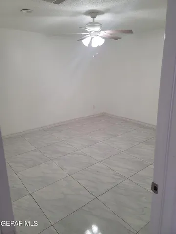 a hall with a chair and wooden floor