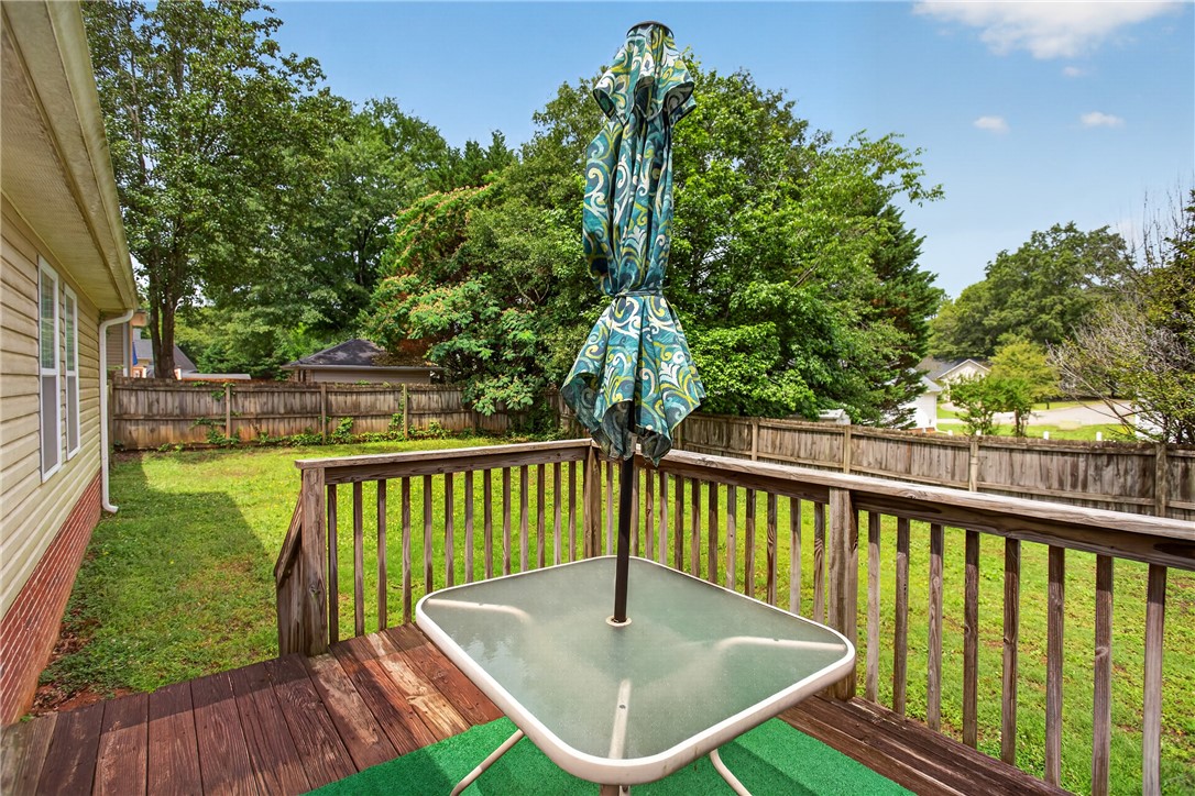 207 Hunters Lane Anderson, SC 29625 - Photo 8 of 46 A classic wooden deck extends to a lush green yard, perfect for outdoor enjoyment.