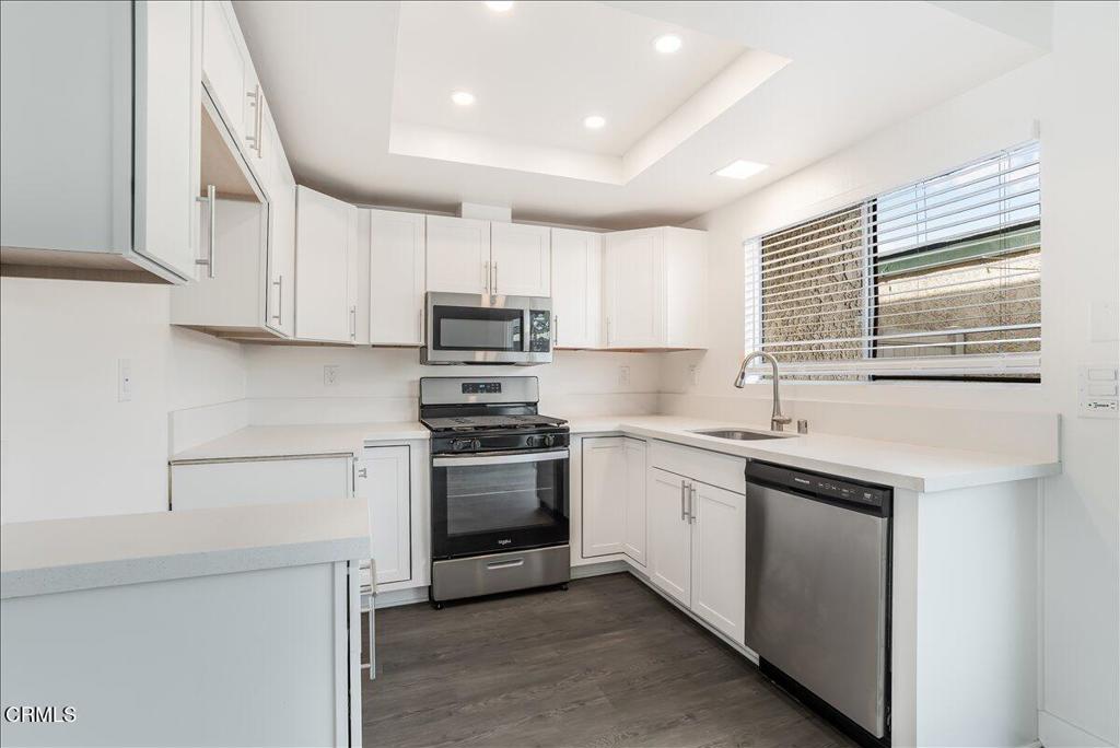 5147 Perkins Road Oxnard, CA 93033 - Photo 11 of 42 a kitchen with stainless steel appliances granite countertop a sink a stove a refrigerator and cabinets