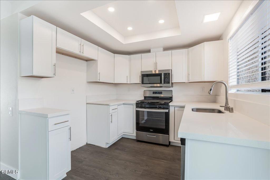 5147 Perkins Road Oxnard, CA 93033 - Photo 13 of 42 a kitchen with stainless steel appliances a stove a sink a microwave and cabinets
