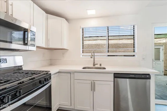 a kitchen with stainless steel appliances white cabinets and a sink