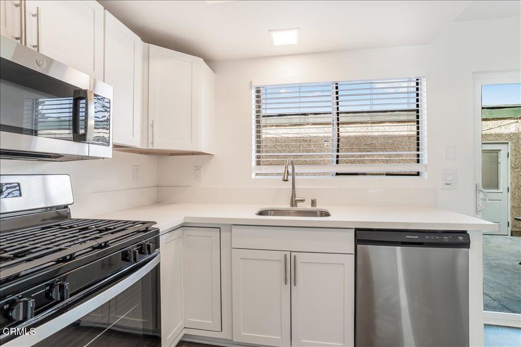 5147 Perkins Road Oxnard, CA 93033 - Photo 14 of 42 a kitchen with stainless steel appliances white cabinets and a sink