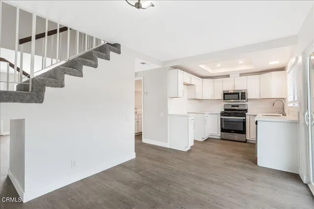 a room with white cabinets and stainless steel appliances