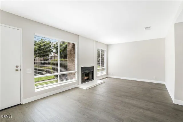 a view of a livingroom with a fireplace wooden floor and window