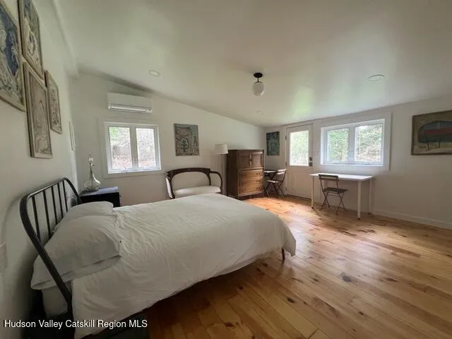 a bedroom with a large bed a chandelier and windows