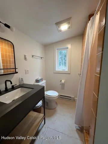 a bathroom with a granite countertop sink toilet a mirror and shower