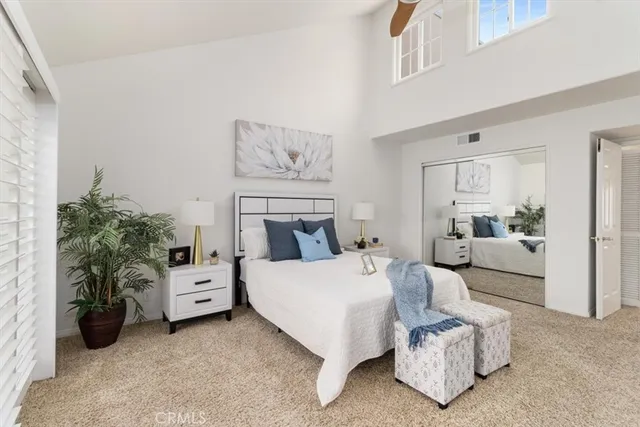 a bedroom with bed and white cabinets