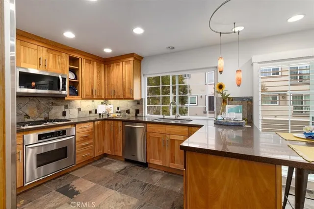 a kitchen with stainless steel appliances granite countertop a stove a sink and a microwave