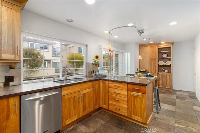 a very nice looking kitchen with granite countertop a sink and a stove