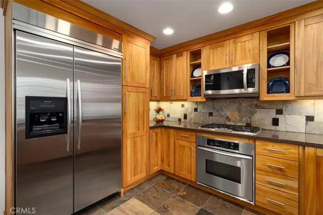 a kitchen with stainless steel appliances granite countertop a stove and a microwave
