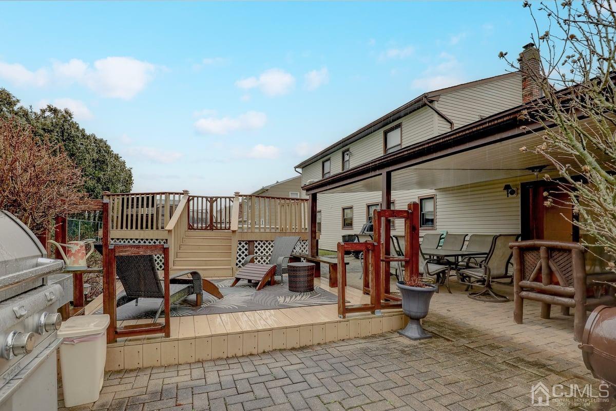 19 North Rhoda Street Monroe Township, NJ 08831 - Photo 22 of 26 a view of a patio with table and chairs with wooden floor and fence